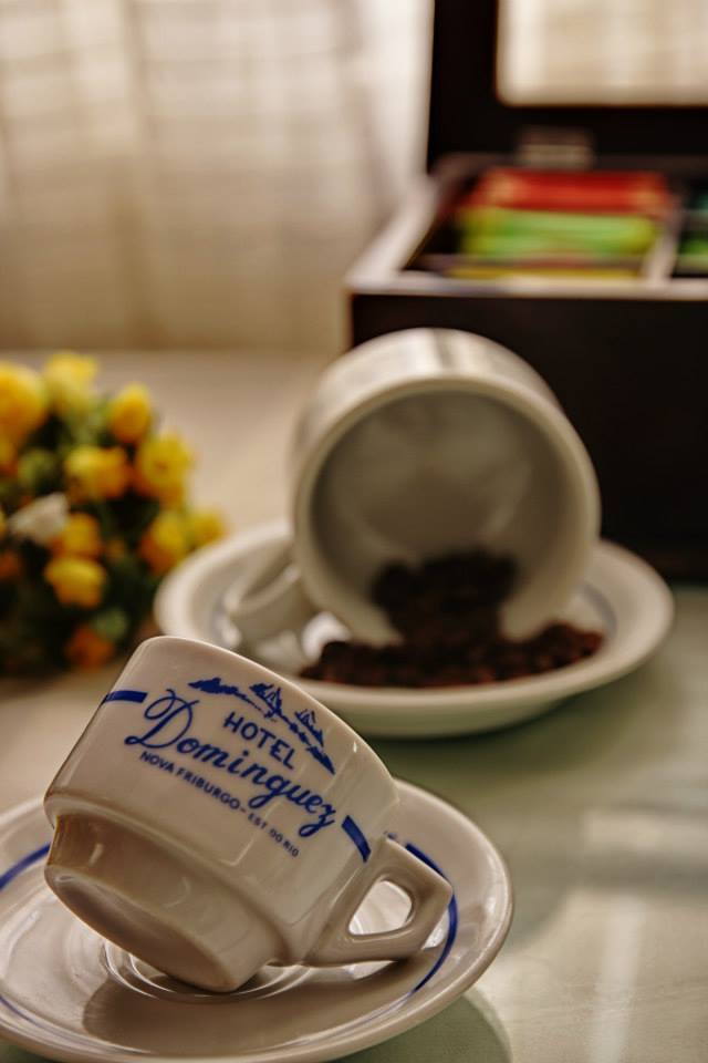 Xícara personalizada Hotel Dominguez sobre mesa do café da manhã