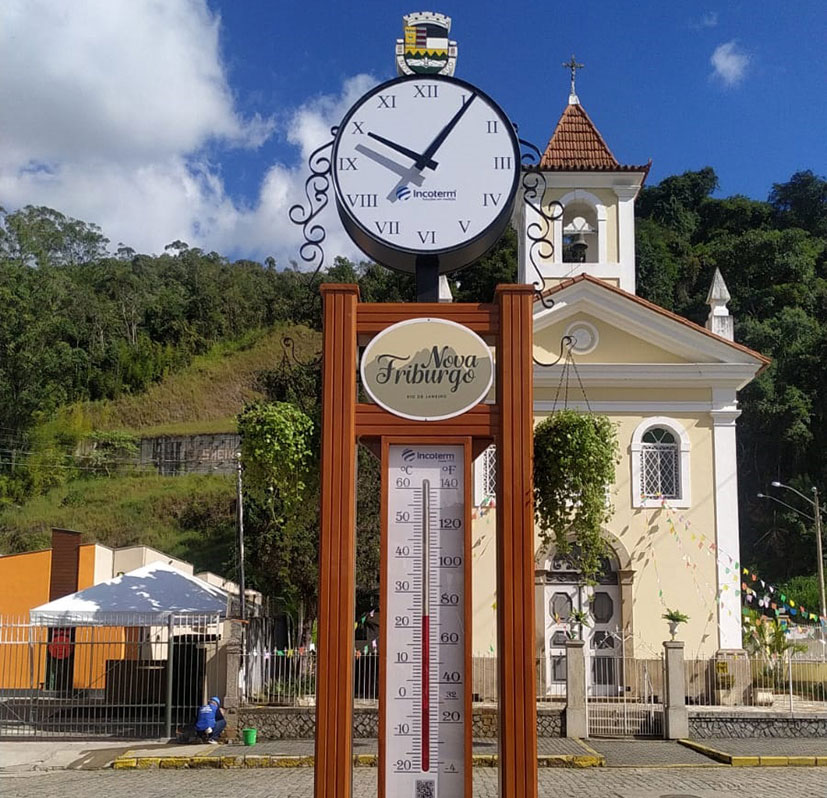 Relógio e termômetro da Praça do Suspiro com a Igreja de Nova Friburgo ao fundo